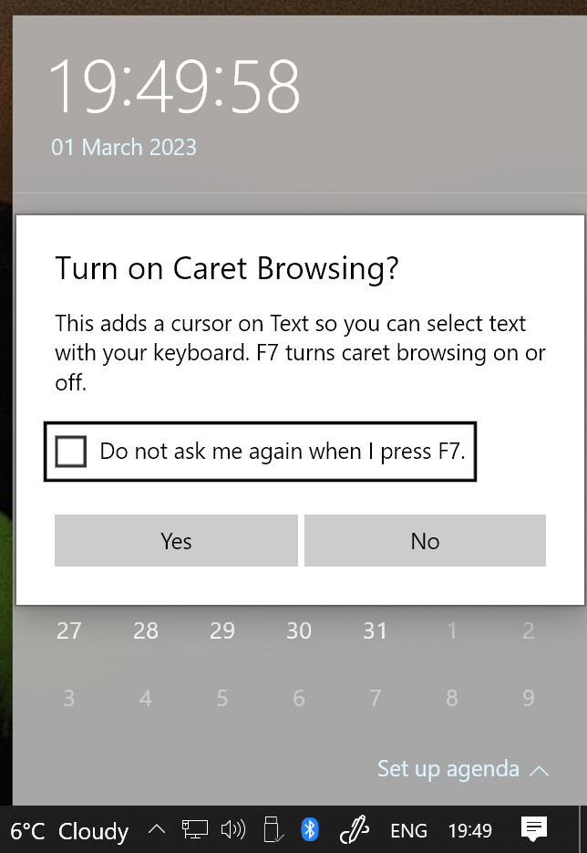 A dialogue box asking to turn on caret browsing over the taskbar calendar flyout window.